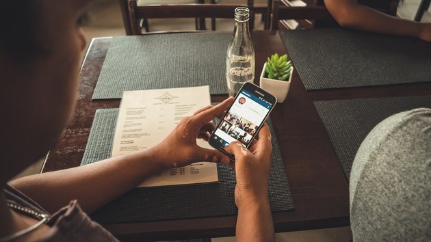 Homem no restaurante usando o Instagram